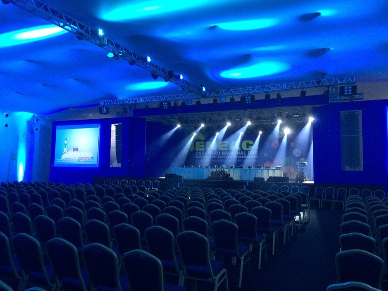 Auditório preparado para um congresso, com palco e iluminação azul